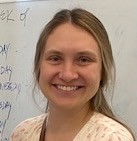 headshot of a scientist smiling in front of the whiteboard