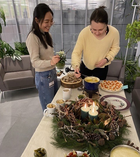One labmate shows another how to enjoy fondue.