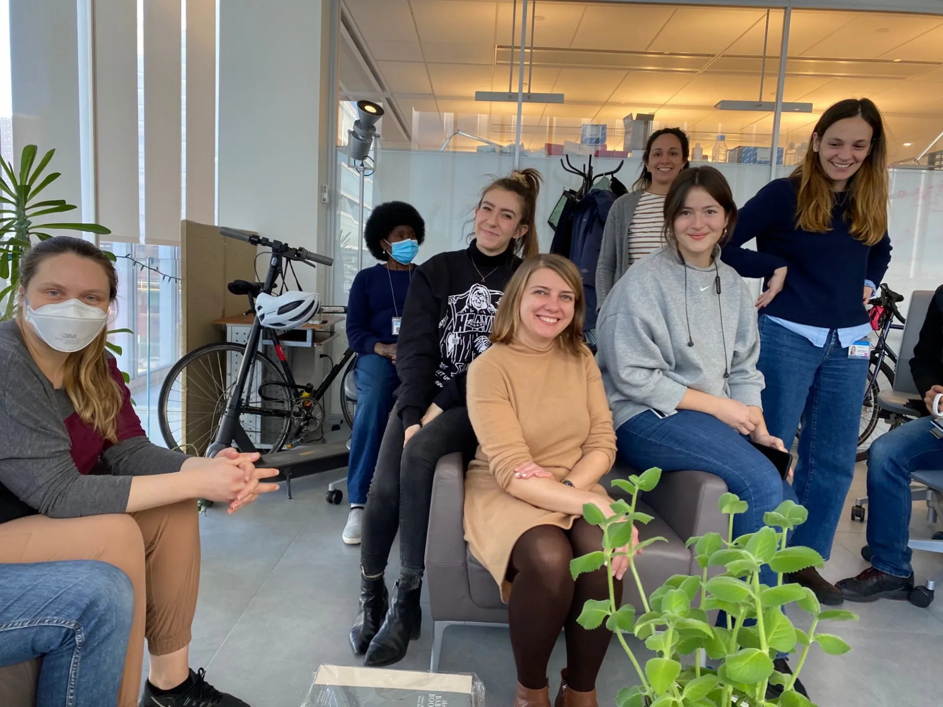 Lab members gather around to hear about Lisa's plans.  Alice, Alexa, Marianna, Joan, Olga, and Albana are seated and standing in a cluster. 