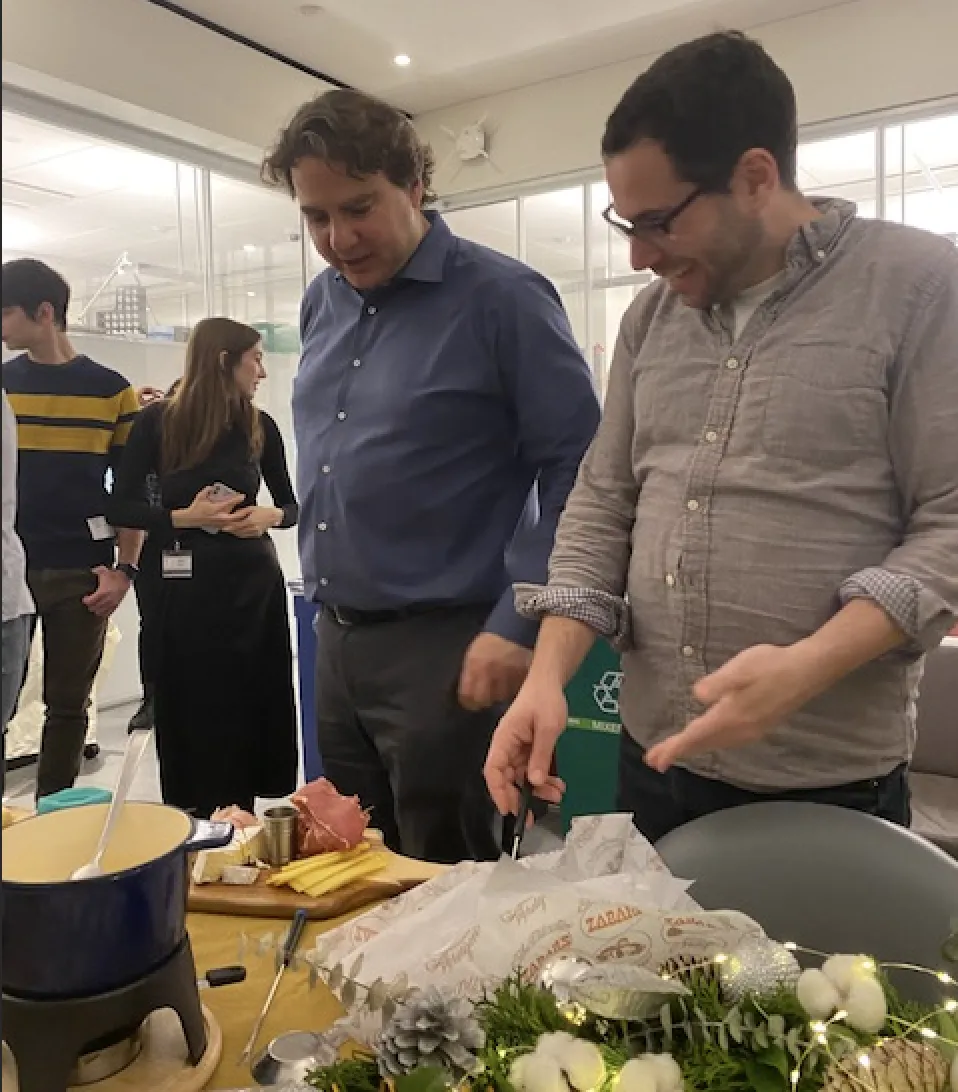 Stavros and Hani arranging or eyeing the charcuterie board