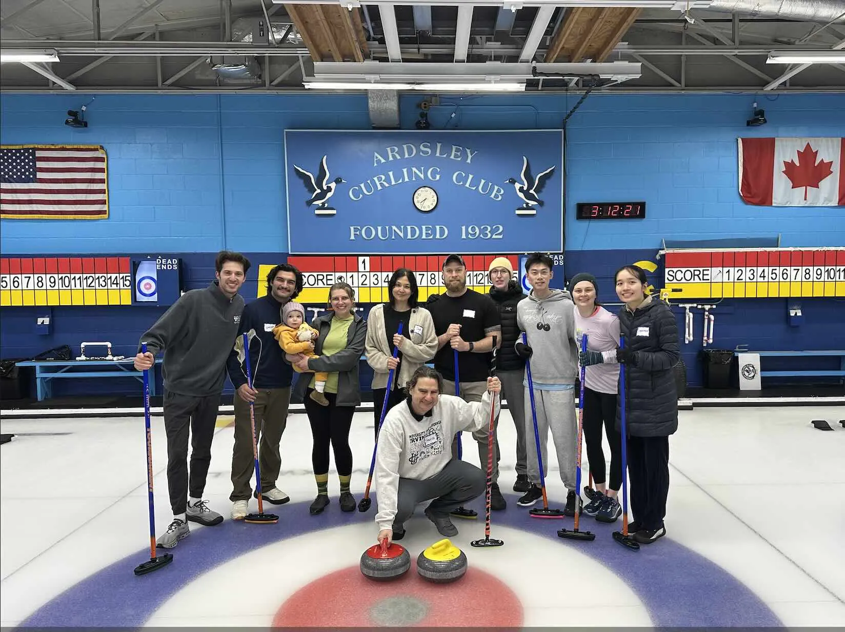 group of people standing in a curling rink