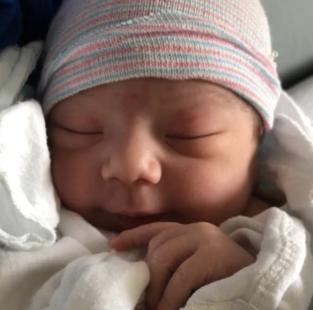 Rachel and Martin's newborn baby in a swaddling blanket